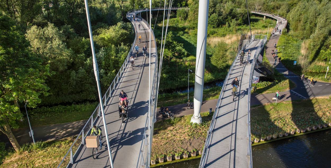 A cycling brigde with people driving their bicycles. 