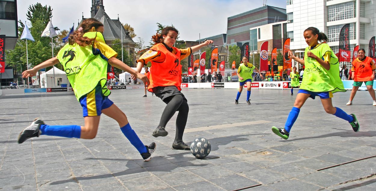Girls playing football at a street tournament. 