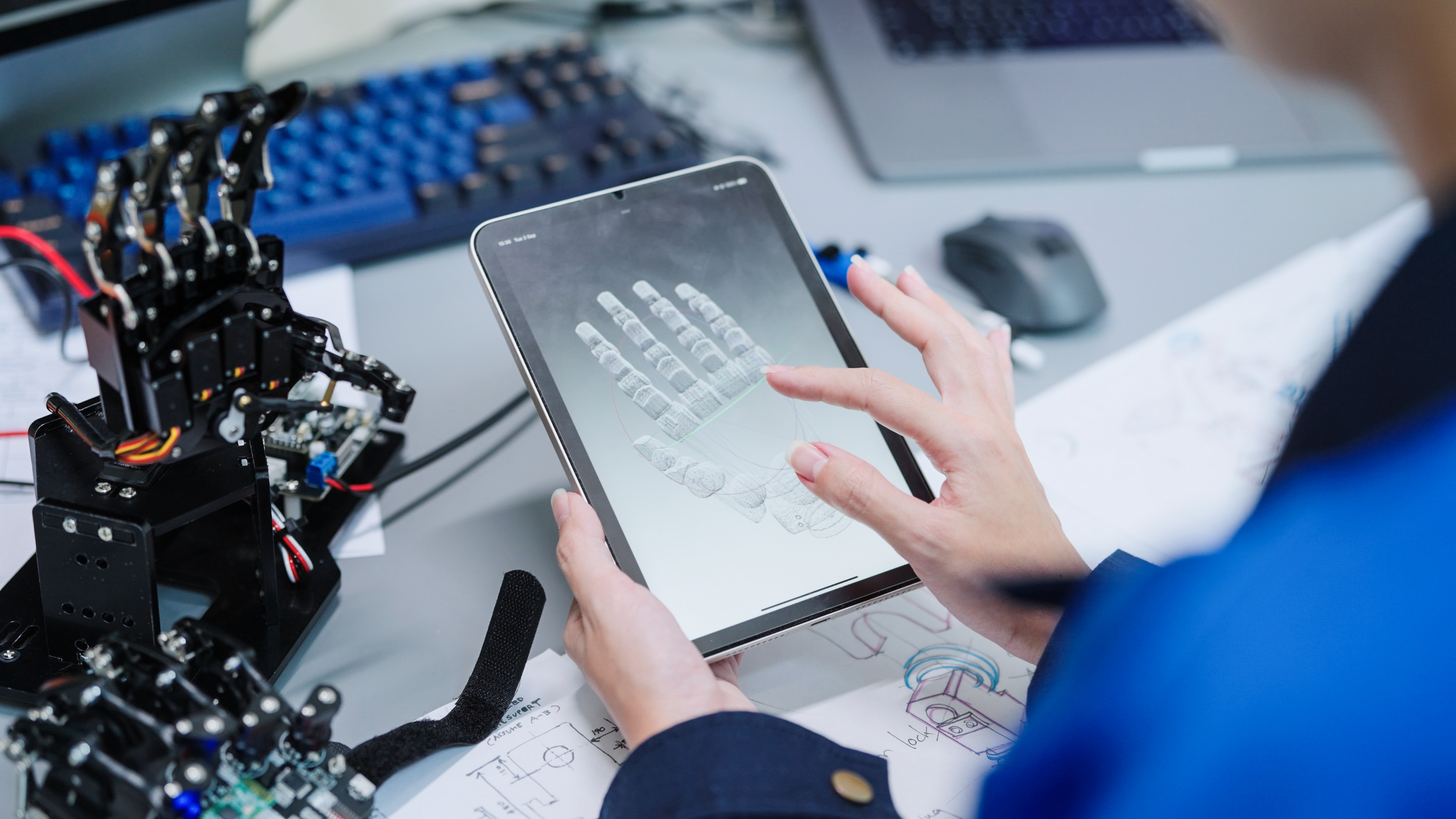 Engineer working on a robot arm with device 